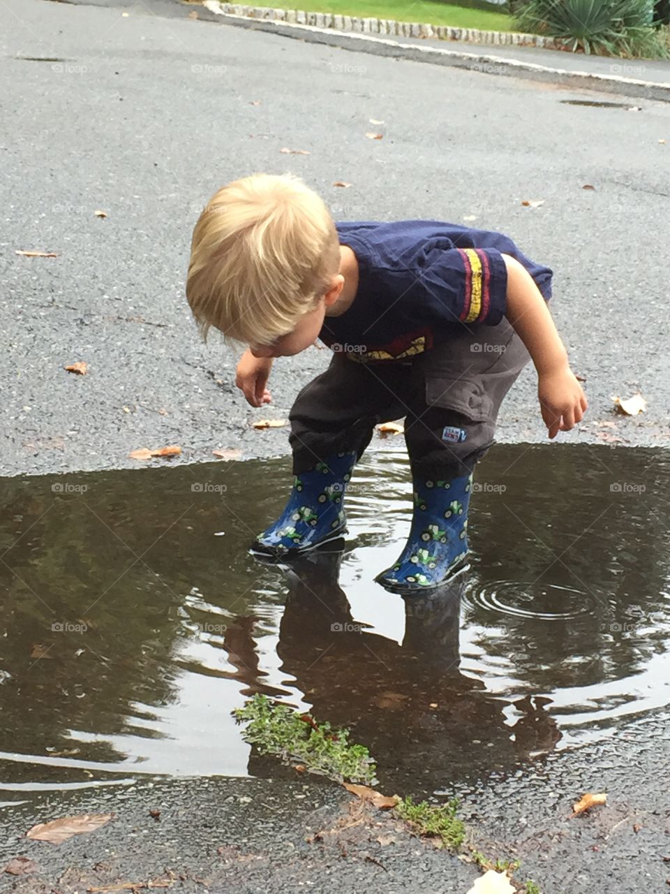 Boy looking at his reflection on water