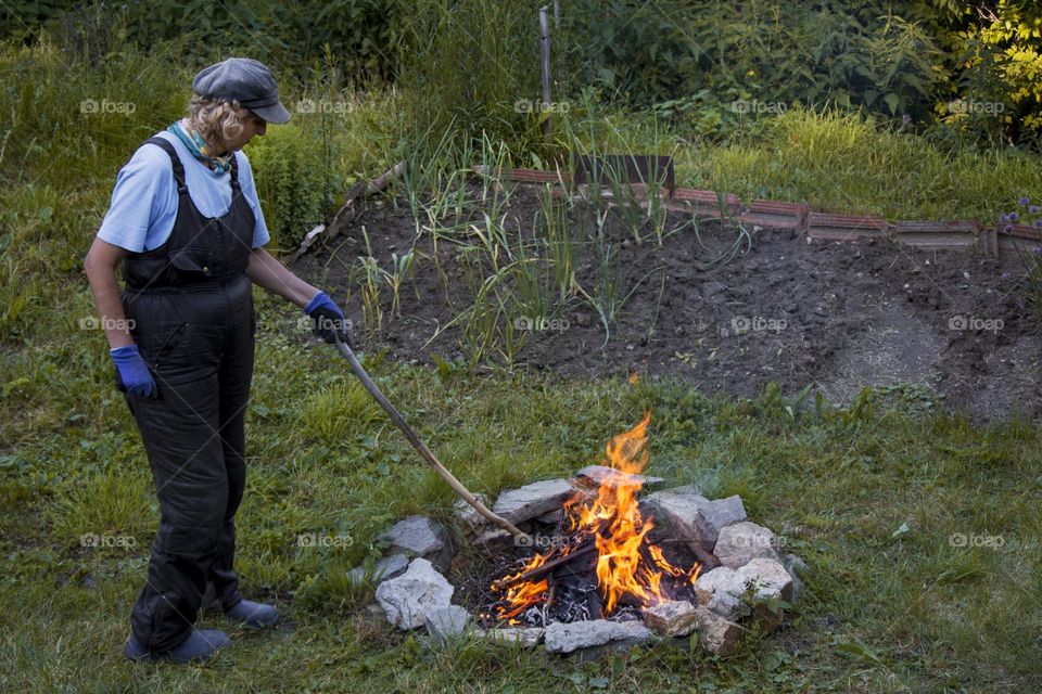 A woman and countryside fireplace at the backyard