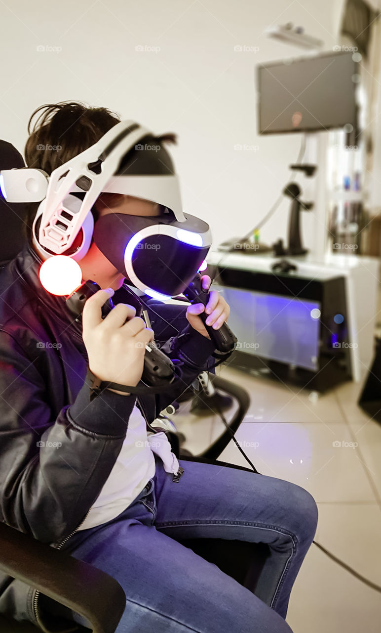 Child with vr glasses playing a virtual game. Concept of modern technology.