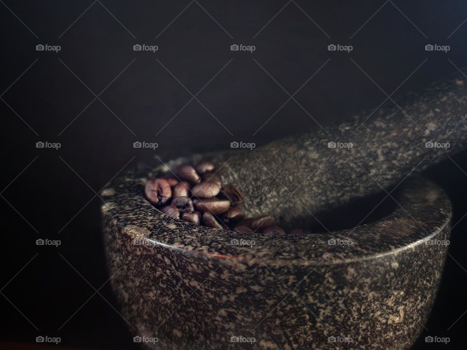 Mortar and pestle with coffee beans to hand grind.