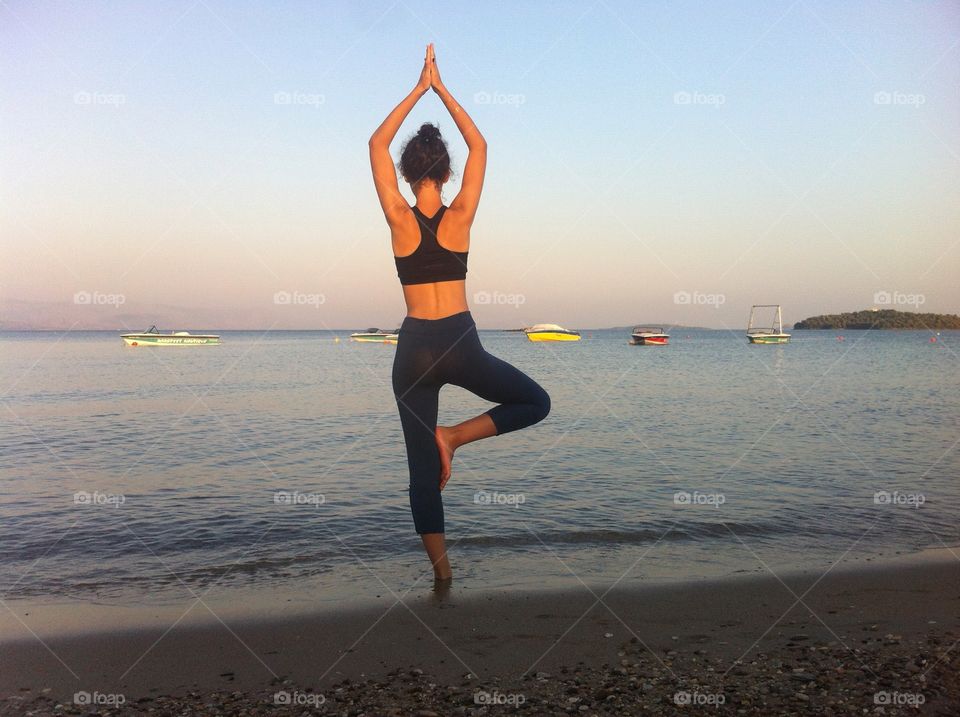 Concentration exercise. Young girl doing a concentration exercise front of the sea during the evening