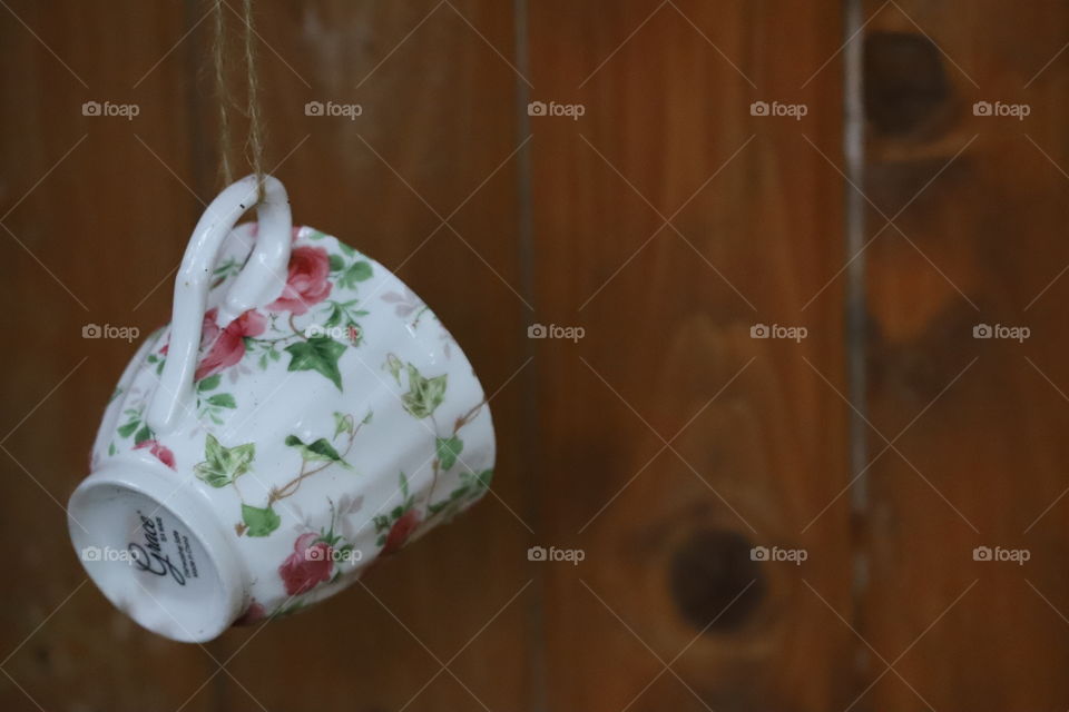 Teacup hanging against the wooden fence