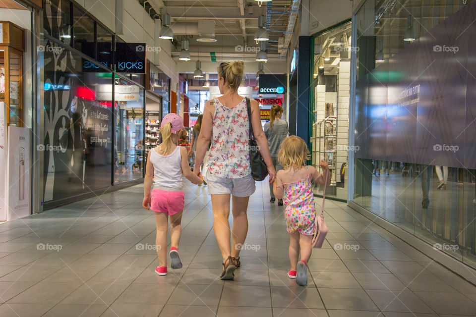 Mom and her two young girls at a shopping mall in Mobilia Malmö Sweden.