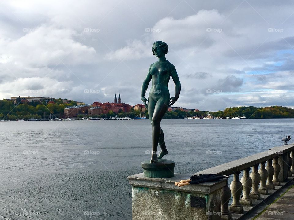 Statue of a woman at city hall in Stockholm, Sweden, overlooking the water, on a cloudy day 