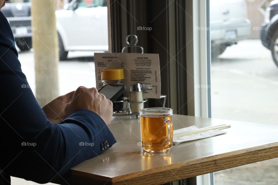 Man sitting in a restaurant checking the menu on the phone 