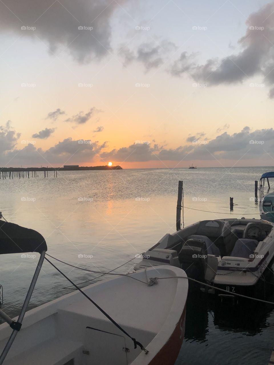 A view of an orange sunset from a boat at the dock on a Caribbean island 
