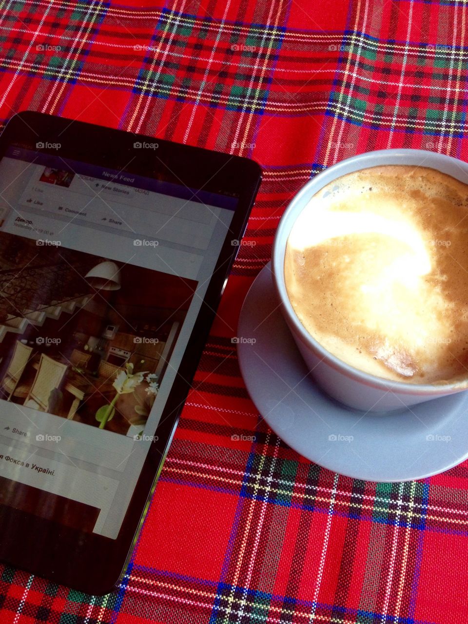 Cappuccino and tablet on a red tablecloth Irish style