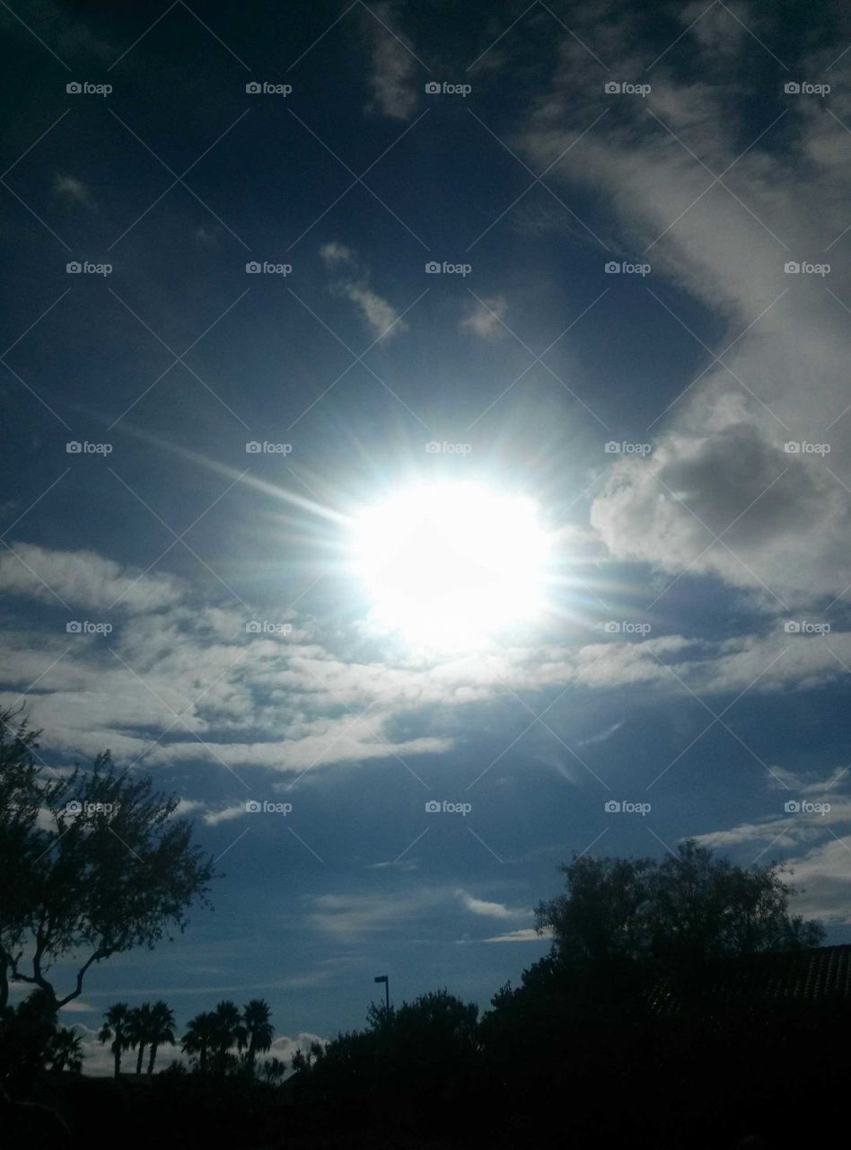 Bright Sun Shining  , As it is setting
Dark Blue Clouds  Surrounding 
Trees Amoung like Dark Shaddows 
Around the midst ..  White clouds 
Complete a Picture Giving 
A Beautiful which is Picture isk