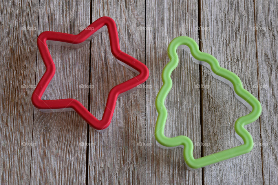 Christmas themed cookie cutters on wood background