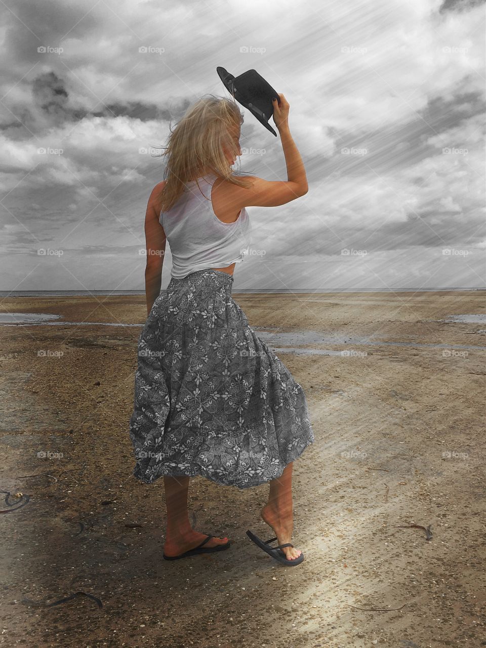 Beautiful blonde Woman in dance Pose on beach at low tide