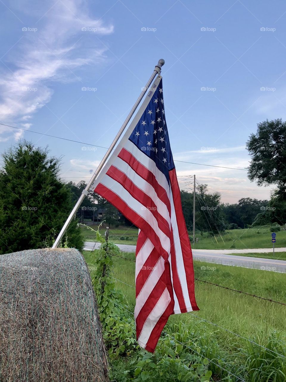 American flag mounted on a hay bale along a rural US road - aka the red, white and blue