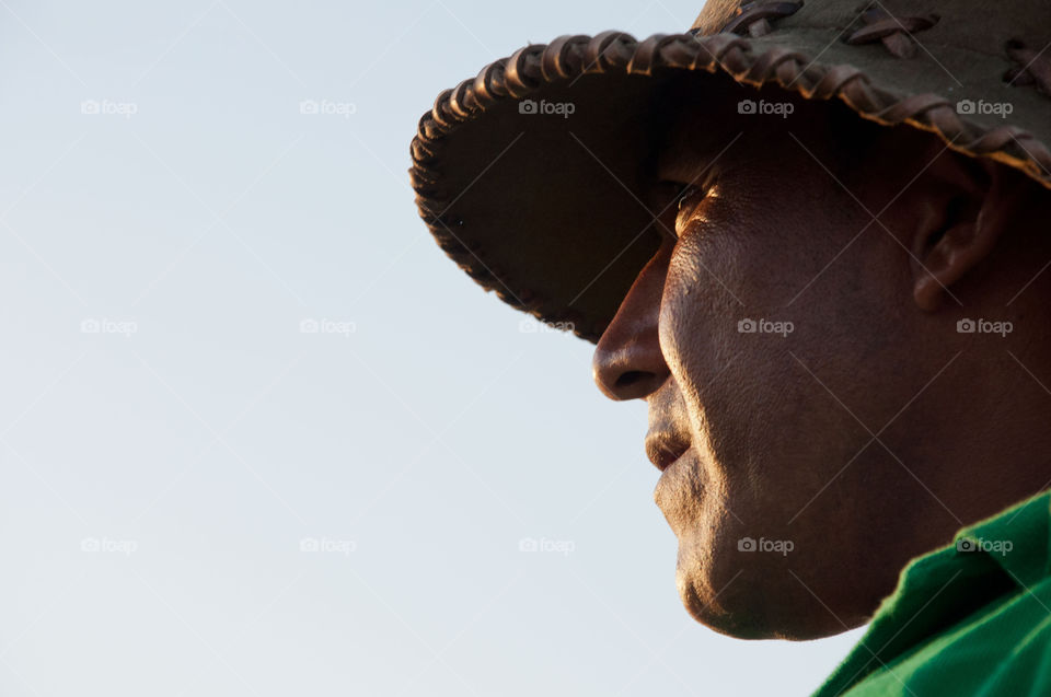 Primer plano de hombre campesino con sombrero de cuero mirando el horizonte 