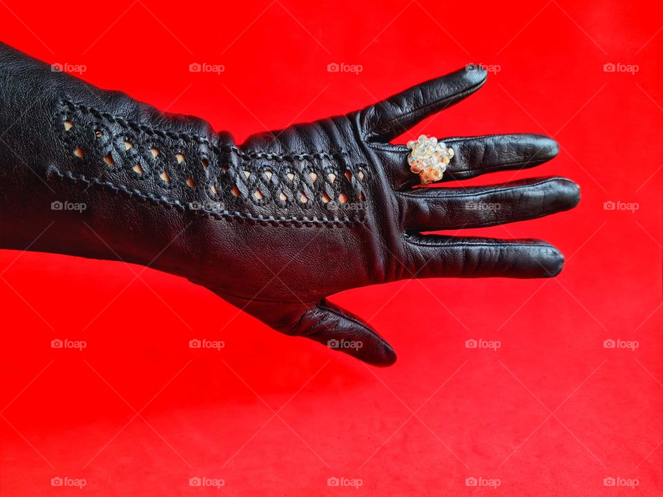 female hand with swarovski ring on black leather glove