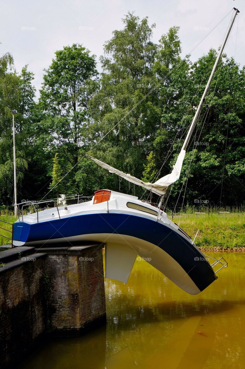 A sail ship on shore near a pool.