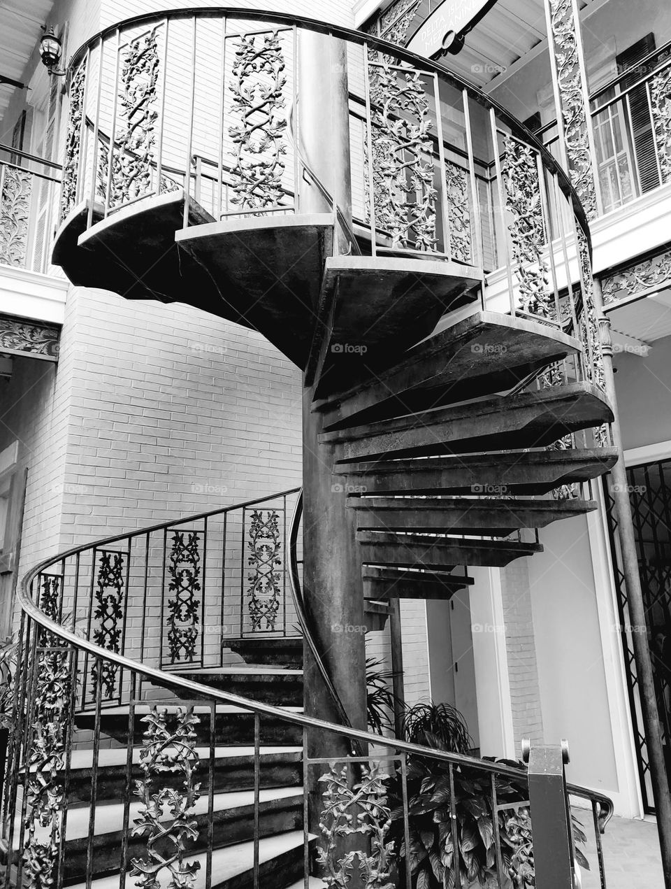 A iron spiral staircase wraps around the center support as if to show off its style and grace