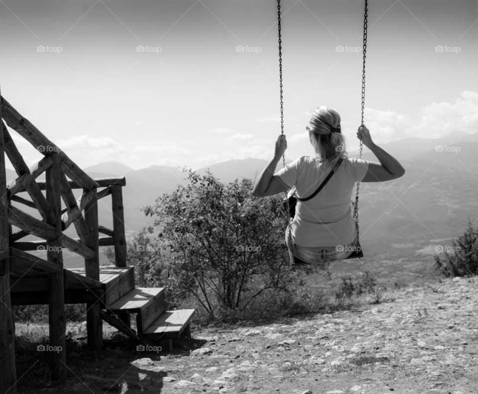 Rear view of woman swinging