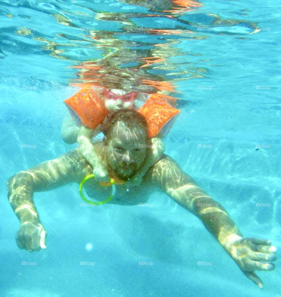 Getting from A to B, father swimming with daughter