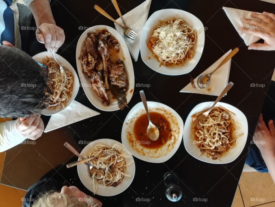 table with plates, whole wheat linguini with cock meat in tomato sauce and cheese