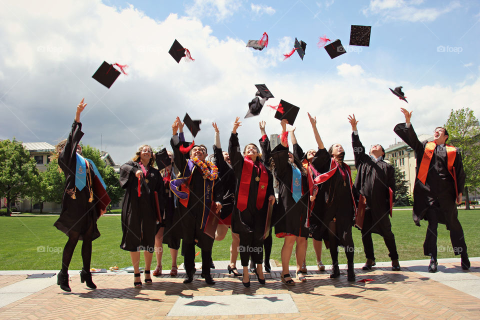 Group of graduates throwing mortar boards in air