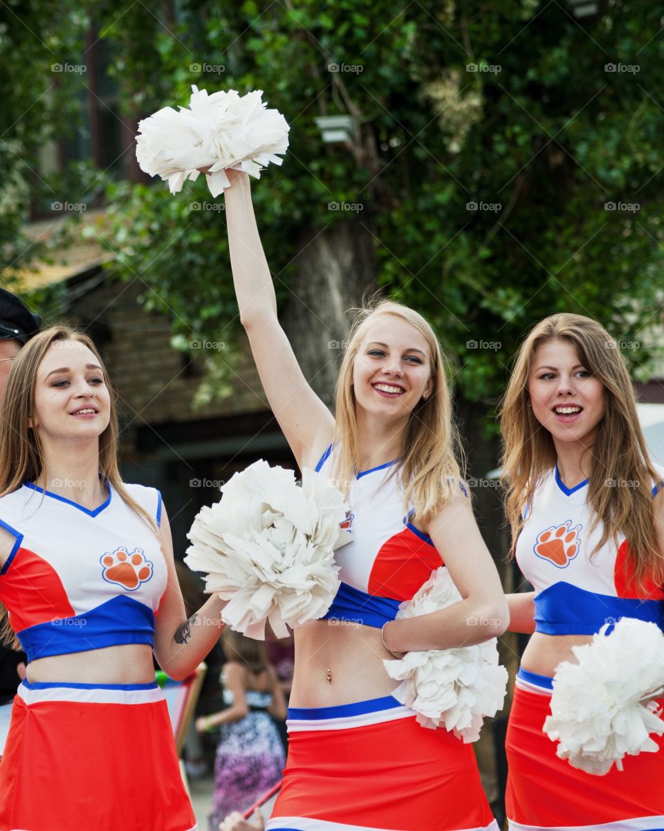Cheerleaders in uniform holding pom-poms
