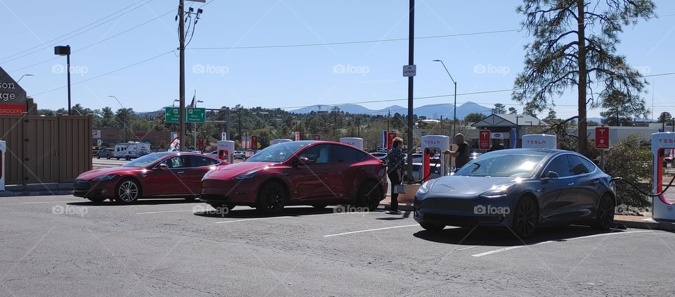 Tesla's Charging, two red one grey