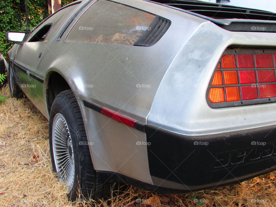 out of commission DeLorean with a dent in the back fender