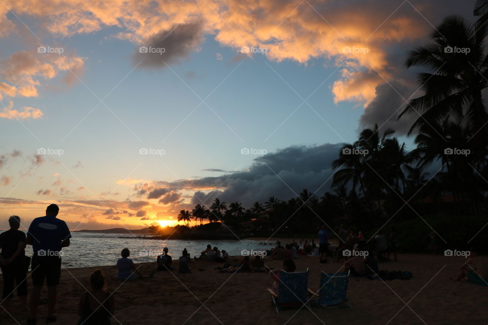 People gathered on the beach to watch the sun setting in