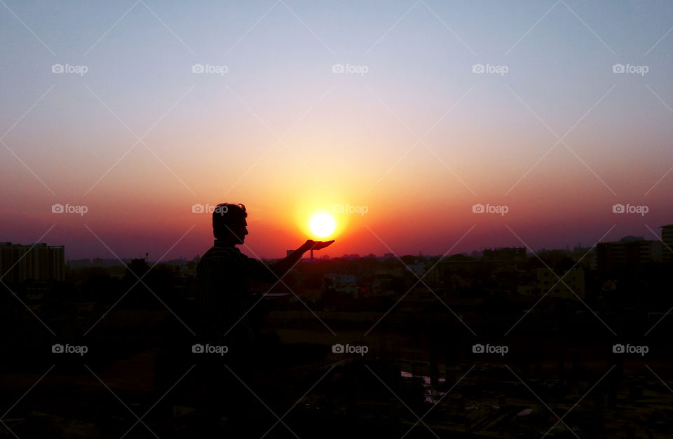 A sun in palm of hand during sunset