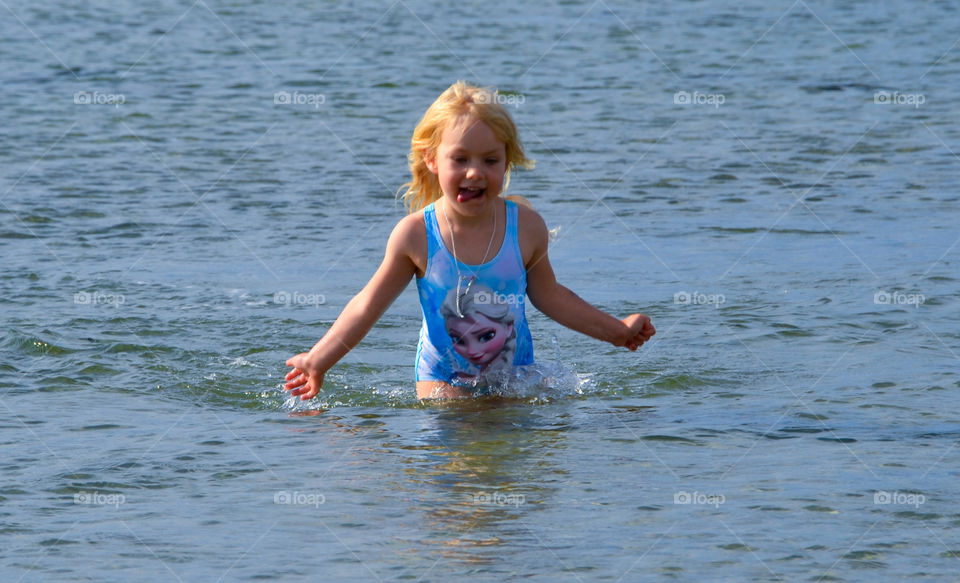 Toung girl of five swimming in the ocean at Ribban in Malmö Sweden.