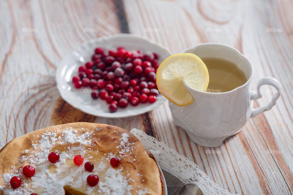 Cheesecake with cranberries and sugar on wooden background