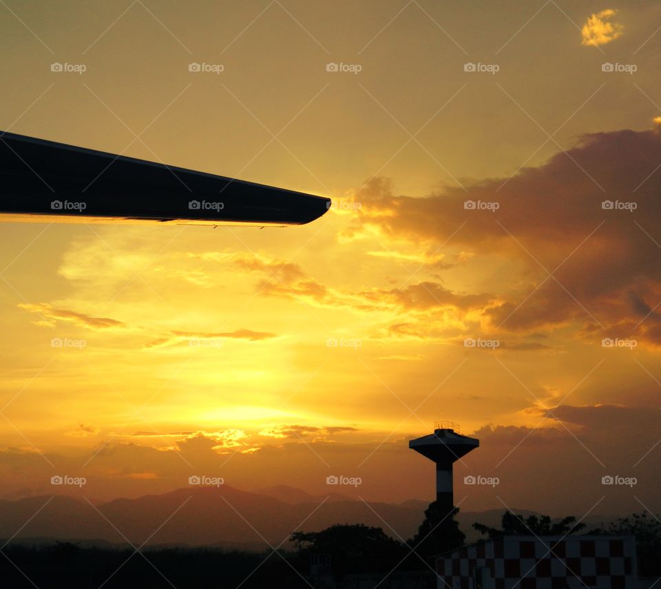 Marvelous view a sunset, an airport tower and aircraft wing at the airport in Santiago de Cuba