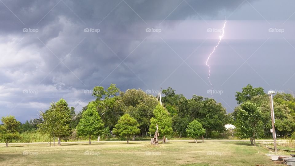 Thunder storm against green landscape