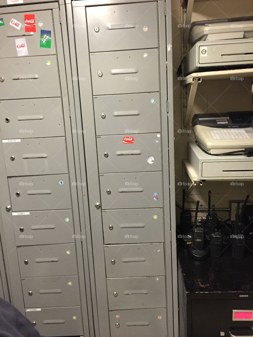 Back room storage space of an office with grey silver lockers and office equipment. 
