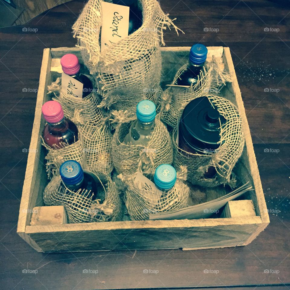 Wooden crate and burlap with wine bottles in as gifts.
