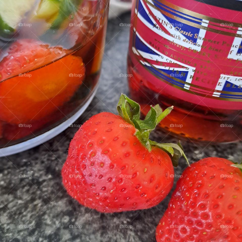 U ion jack flag on bottle of alcohol next to jug and strawberries