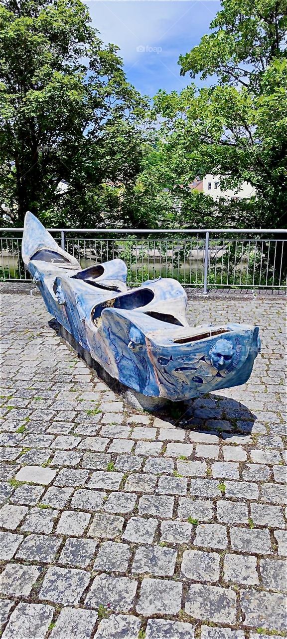 What looks like a large piece of naval machinery turned art object, painted and decorated with relief faces on this sidewalk in “Kelheim”, Bavaria may have originated as an artwork entirely. We simply don’t know. 2024. Hypnotic Productions