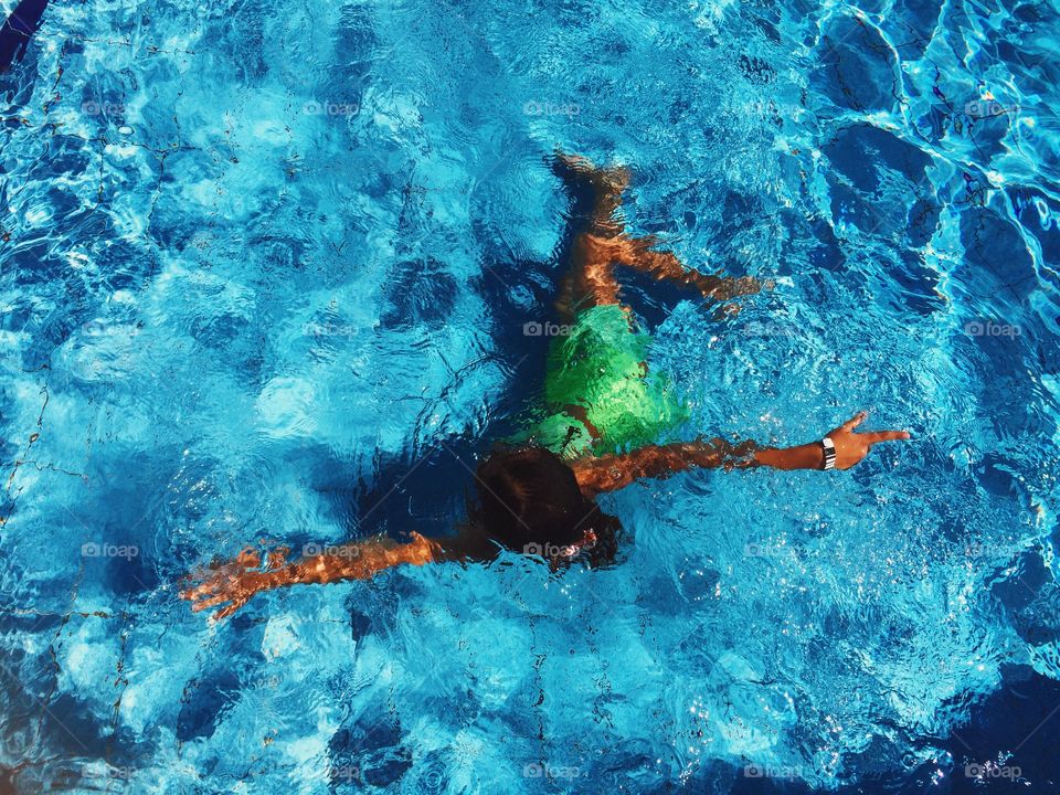 Young woman swimming underwater in the swimming pool