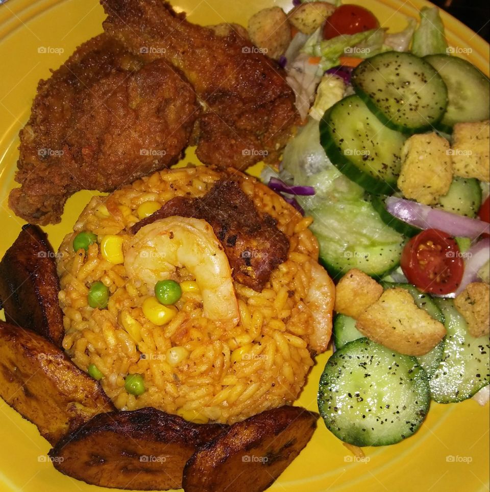 Jollof Rice, plantain,  fried wing dings and salad