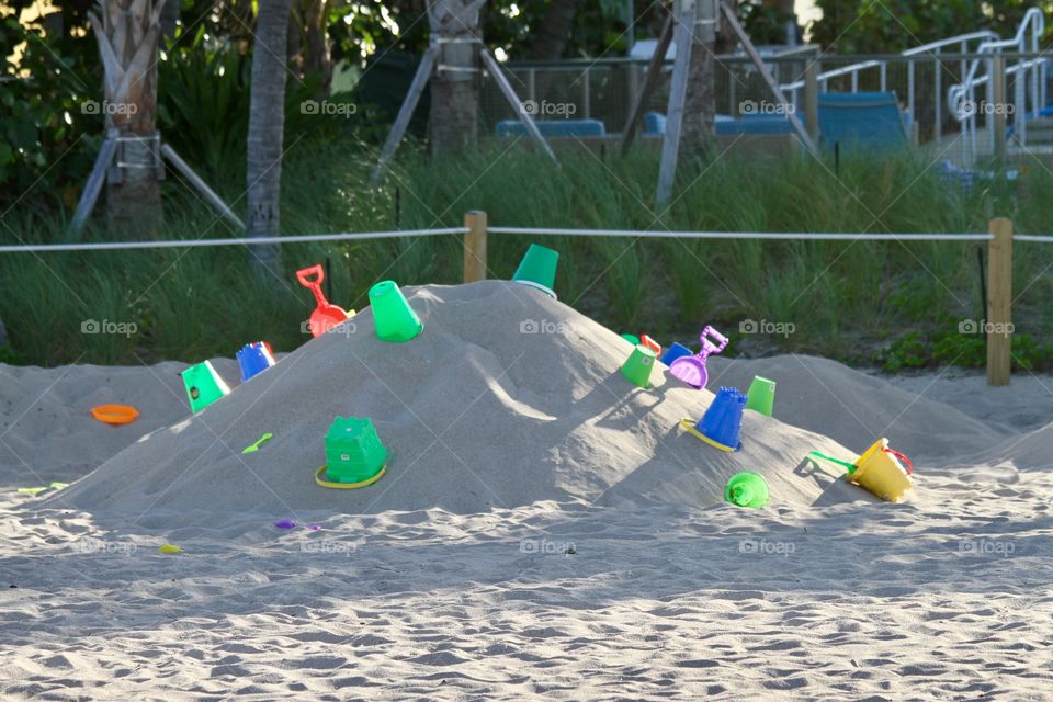 Sand pile with toy buckets