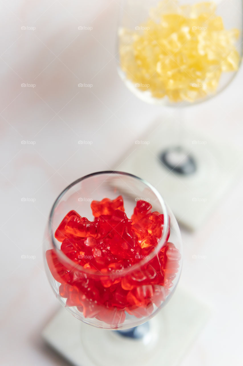 Red and white wine glasses full if gummy bears