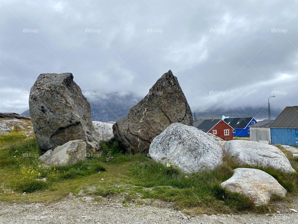Large boulders and brightly colored houses in a small village in Greenland 