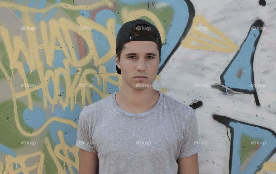 Serious man against graffiti wall