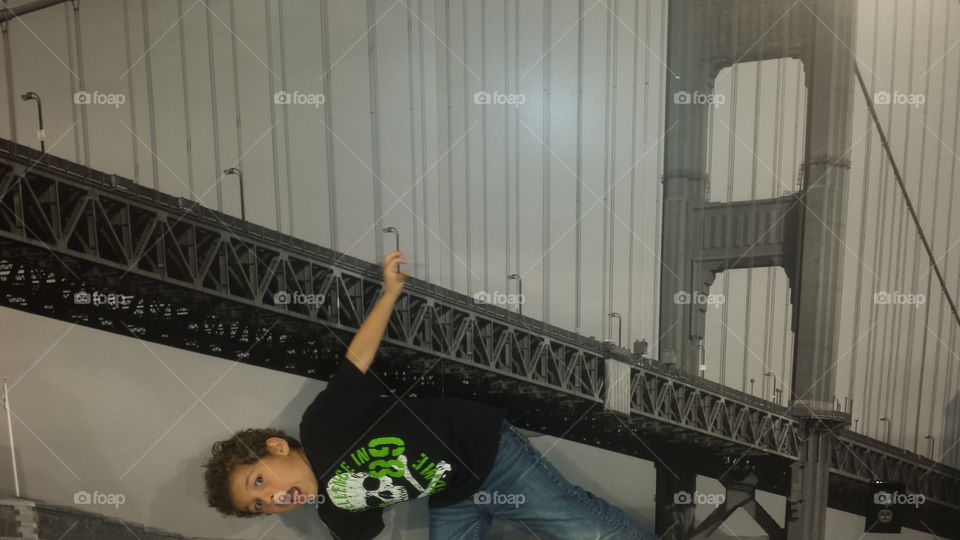 Boy hanging on bridge