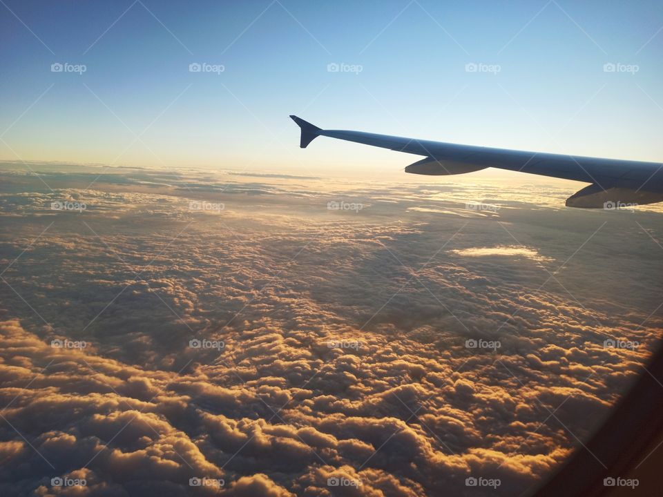 wing of a plane flying above thick dark clouds