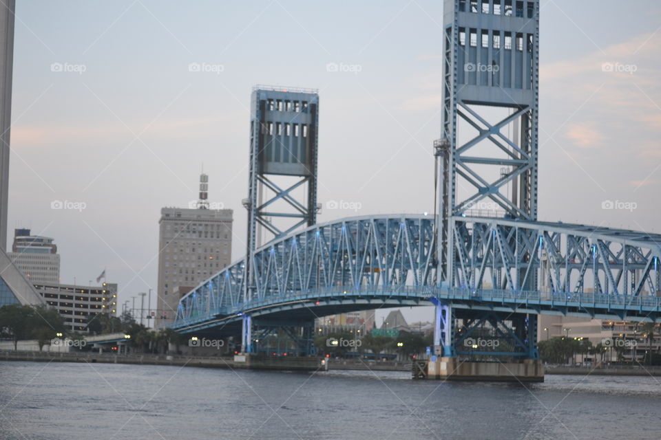 A large, blue metal bridge crossing over a river