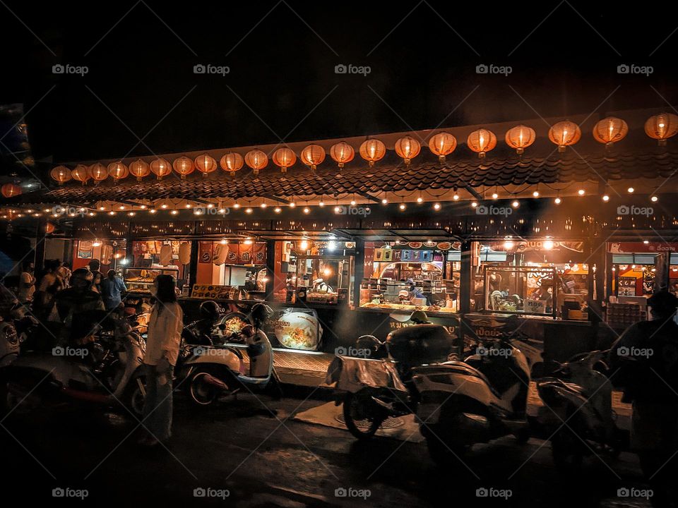 Chinese restaurant view from outside in night time. Round shape red lantern along the roof is the unique design