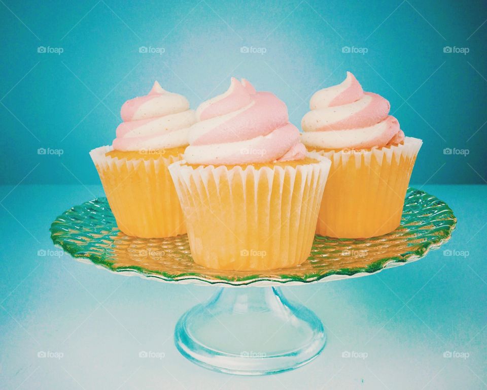 Three delicious frosted cupcakes on a platter. 