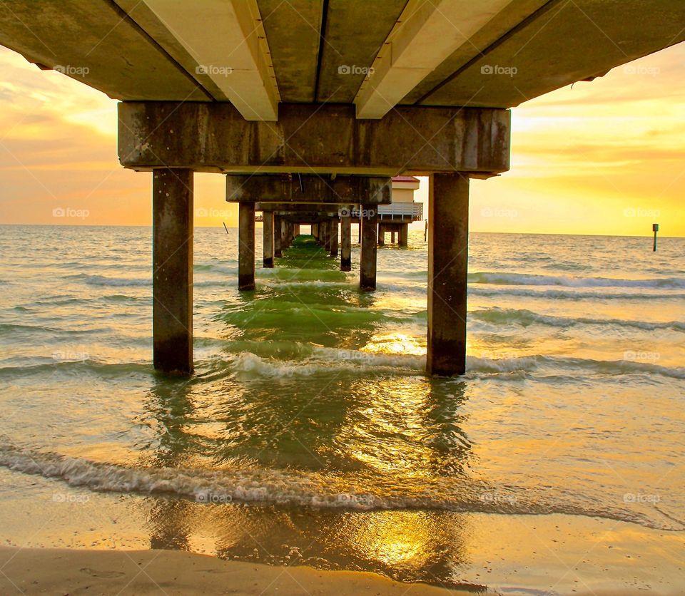 Golden sunset under the pier at Clearwater Beach 