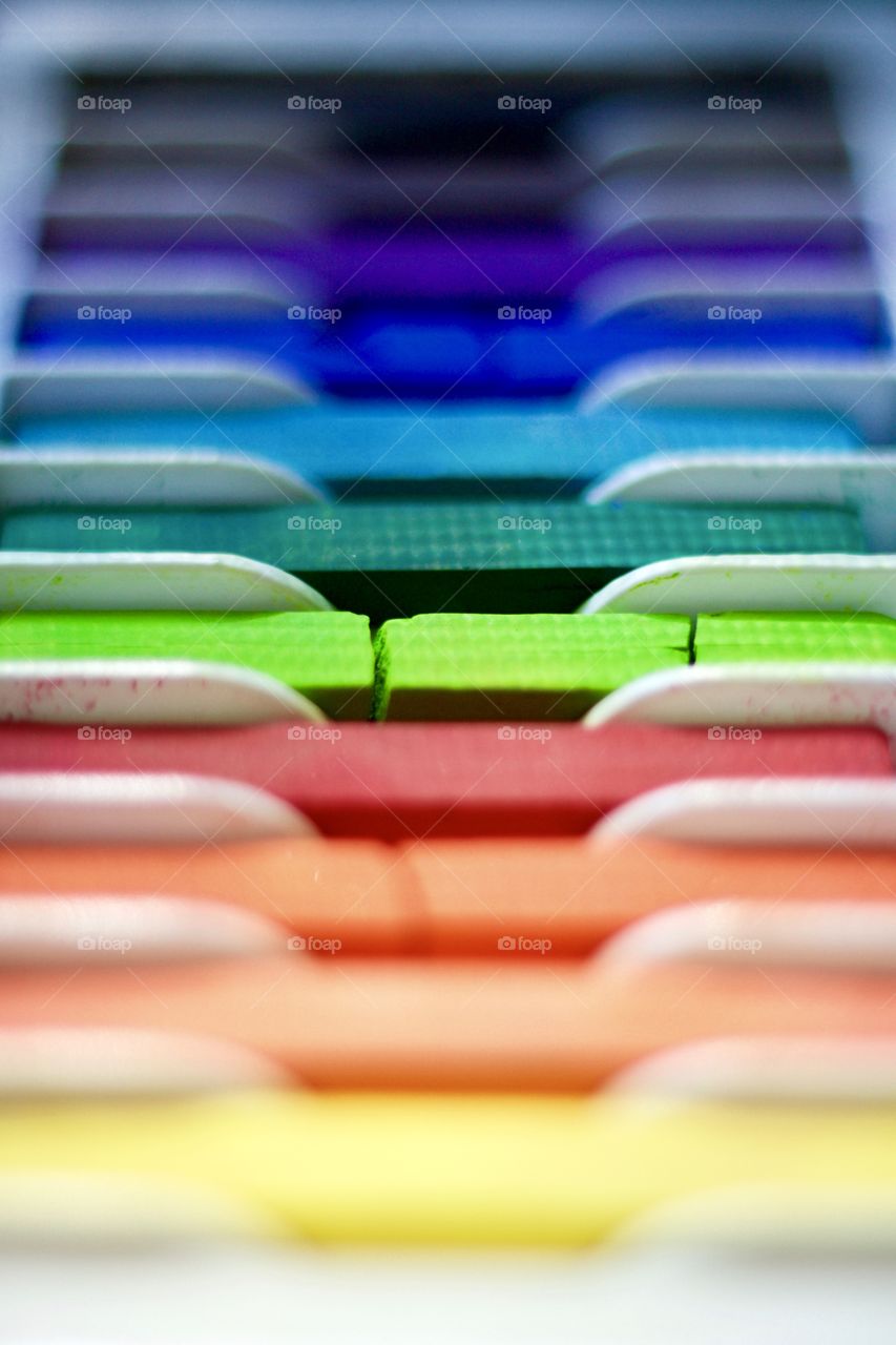 Color Love - low-angled view of a set of chalk pastels in a tray in natural light 