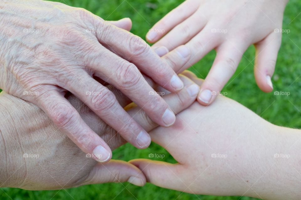 A Family represented by the hands of a Mother, Daughter, and Grandchildren.